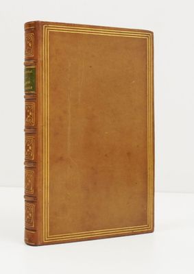 an old book with a brown cover sitting on top of a white table