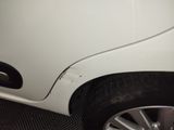 a close up of a white car with a denting on it