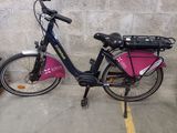 un vélo garé sur un parking, avec un sac à l'arrière