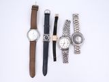 quatre montres différentes sont alignées sur une surface blanche
