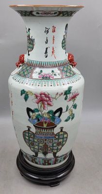 un grand vase orné de fleurs, posé sur un socle
