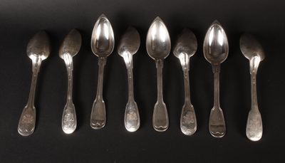 six spoons are lined up in a row on a black surface
