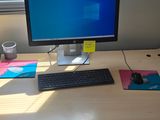 a desk with a computer monitor and keyboard on it