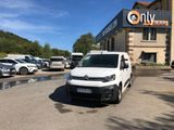 the white van is parked in front of a building with many cars parked in front of it