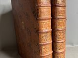 two old books sitting on top of a table next to each other