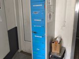a blue locker in a room with a trash can