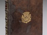 un vieux livre avec un emblème en or sur la couverture