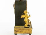 a gold statue of a cupid sitting on a black box