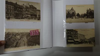 a person holding a book open to a picture of a city