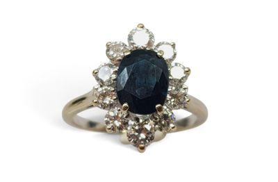 gros plan d'une bague avec une pierre bleue entourée de diamants blancs