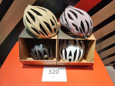 trois casques dans une boîte posée sur une table, avec une étiquette de prix