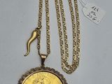 un gros plan d'un collier composé d'une pièce d'or suspendue à une chaîne