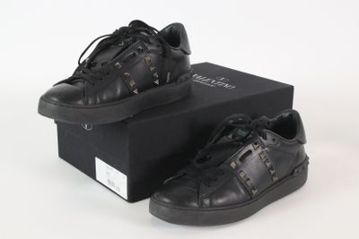 Il s'agit de deux paires de baskets noires ornées de clous.