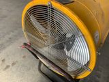 a yellow fan sitting on top of a cart in a garage