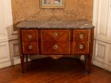 une commode au plateau en marbre, placée dans un coin de la pièce