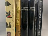 trois livres sont empilés sur une table