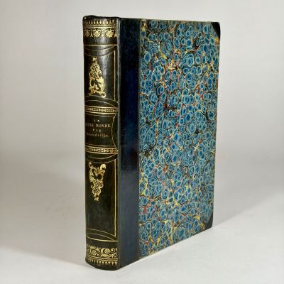 a blue book with gold trim sitting on top of a white table