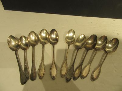 six cuillères en argent sont alignées sur une table