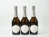 trois bouteilles de champagne posées les unes à côté des autres sur une surface blanche