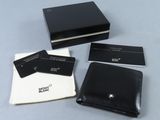 trois portefeuilles en cuir noir et un porte-cartes posés sur une table