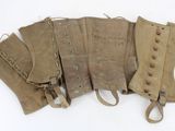 four pairs of leather boots are lined up on a white surface