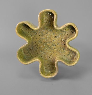 an image of a green vase with a flower shaped design on it