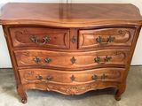 une commode en bois surmontée d'un miroir