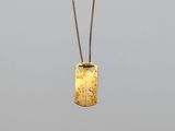 un collier avec une plaque d'identité en or sur laquelle figure la lettre « s »