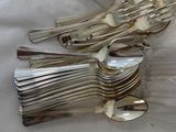 a lot of silver spoons and forks on the table