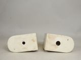 pair of white ceramic bookends with holes in the middle of them