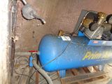 a blue air compressor sitting in the corner of a room