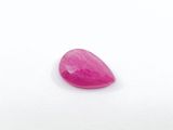 a close up of a pink stone on a white surface