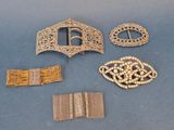 several pieces of silver and gold jewelry on a blue surface