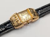 a watch that is sitting on a black leather strap