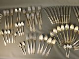 a lot of silver spoons and forks on a table