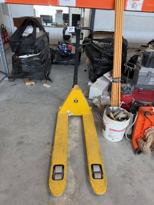 un chariot élévateur dans un garage, à côté d'autres outils