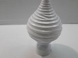 a white vase that has a spiral design on it