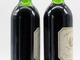 two bottles of wine sitting next to each other on a table