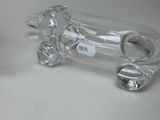 a glass dog shaped object on a table next to a glass bottle