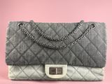 a grey and white quilted bag with a chain strap