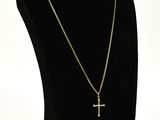 a black mannequin with a gold cross on it