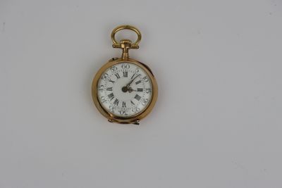 une petite montre de poche en or avec des chiffres romains