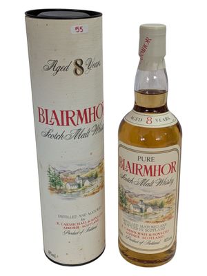 une bouteille de whisky posée à côté d'une boîte en carton