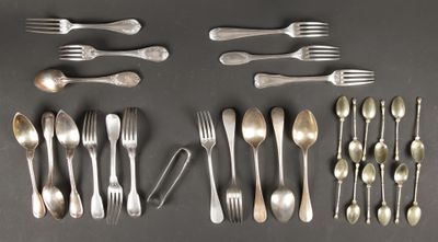un grand nombre de cuillères et de fourchettes disposées sur la table