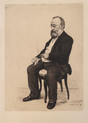 portrait d'un homme en costume assis sur une chaise