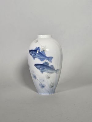 un vase blanc orné d'un motif représentant un poisson bleu