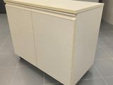 a white cabinet sitting on top of a tile floor