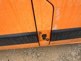 a close up of a door handle on an orange van
