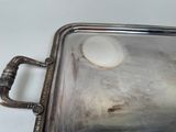 a silver tray with a handle on a white table