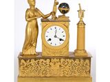 une horloge en or surmontée d'une statue